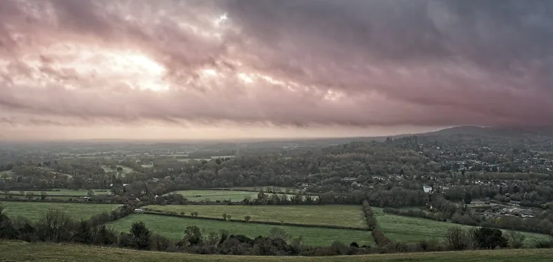 Misty morning panorama from Box Hill, with hedged fields and low cloud stretching across the Weald