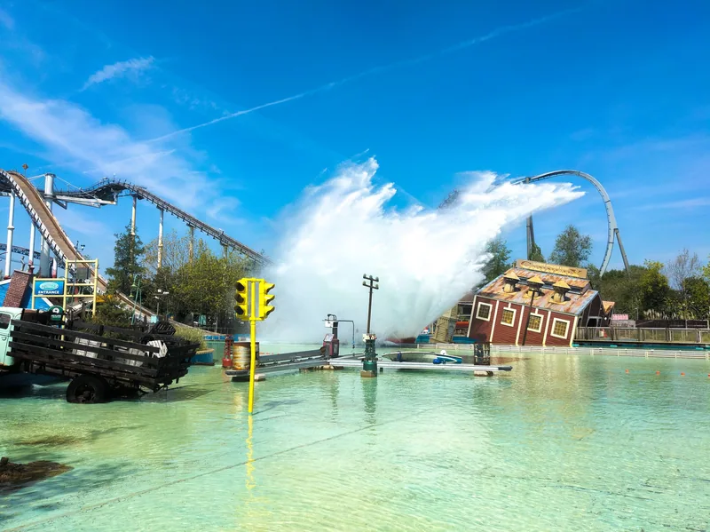 A water ride throwing up a wall of spray beside the lagoon at Thorpe Park