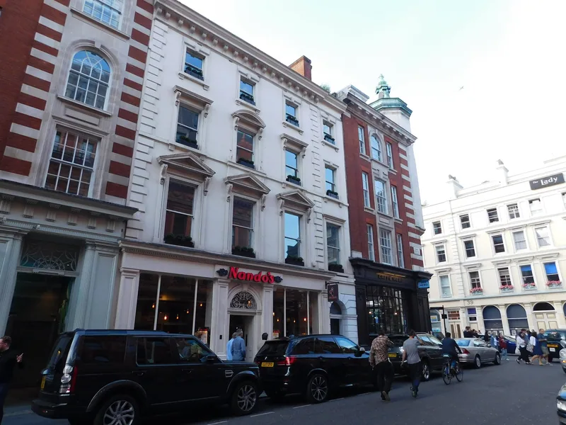 A Nando's on the ground floor of a white stucco terrace on Chandos Place in central London