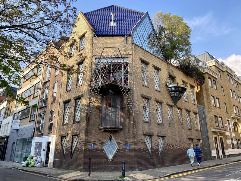 The brick corner house at 44 Britton Street in Clerkenwell, with diamond-paned windows, a caged balcony and a blue-tiled roof