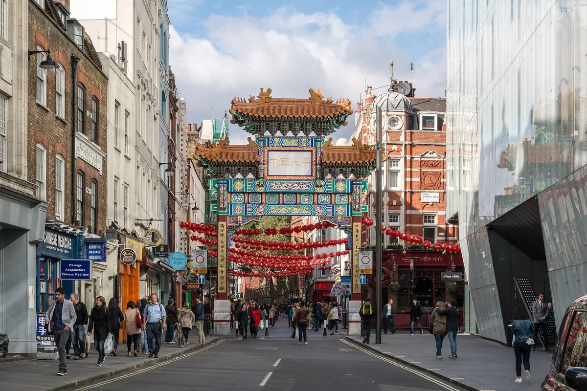 The Chinatown gate in London with red lanterns strung above the street and shopfronts