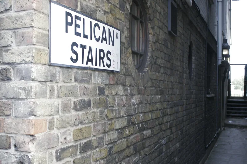 The narrow brick alley beside the pub running down to Pelican Stairs, the old street plate fixed to the wall