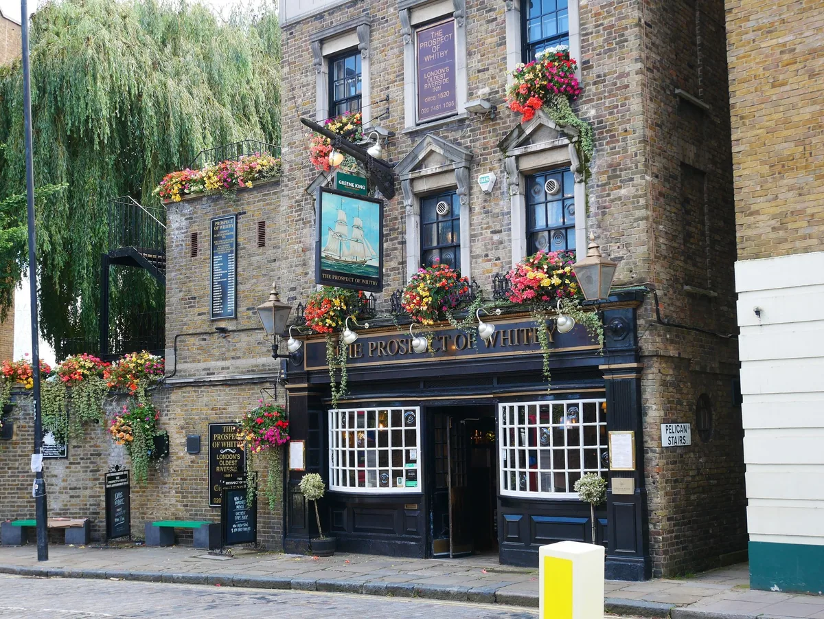 The Prospect of Whitby pub in Wapping, its dark frontage hung with flower baskets and a painted pub sign