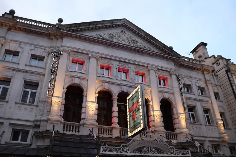 The floodlit facade of a West End theatre on St Martin's Lane at twilight