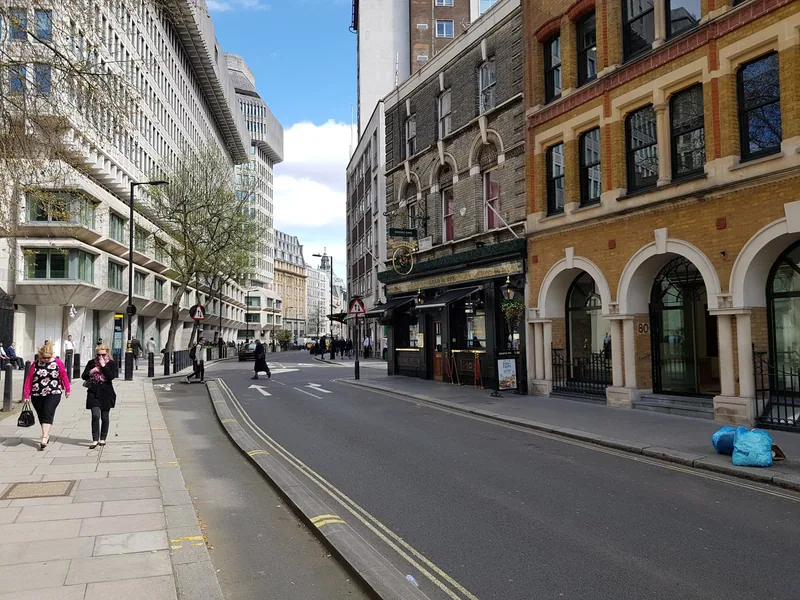 Petty France in Westminster, a wide street of offices with a traditional pub and its menu boards on the corner