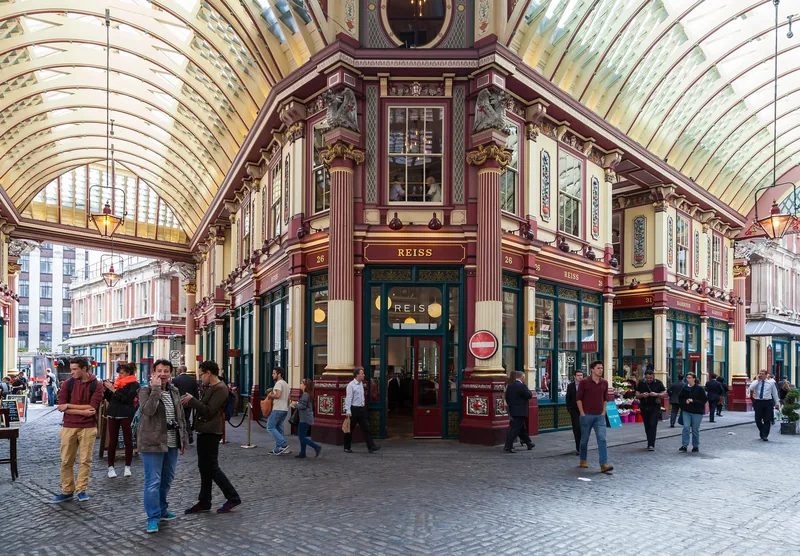 The painted ironwork and glass roof of Leadenhall Market over its cobbled crossing in the City of London
