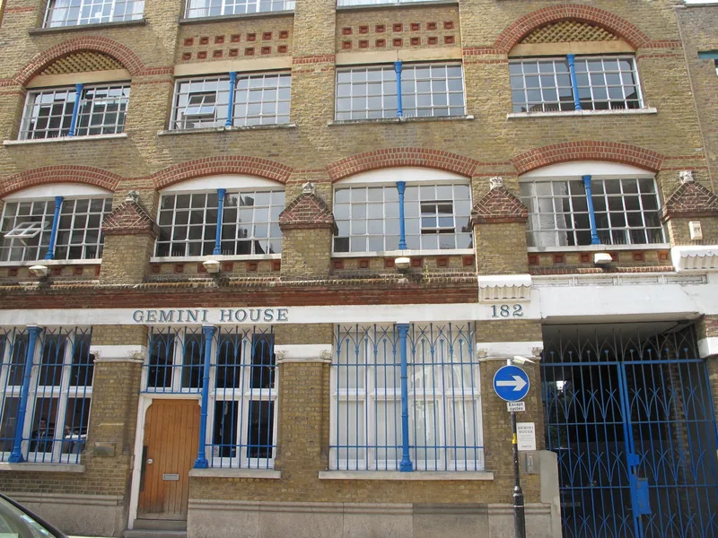 The yellow-brick front of Gemini House on Bermondsey Street, with blue-painted iron columns and tall warehouse windows