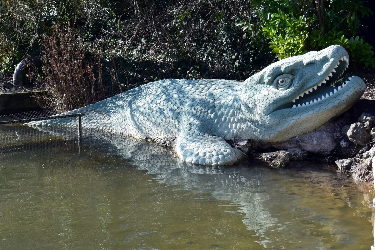 The Victorian Mosasaurus sculpture at the water's edge in Crystal Palace Park