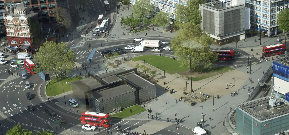 Aerial view of Elephant Square with red double-deckers on the roundabout and a green lawn