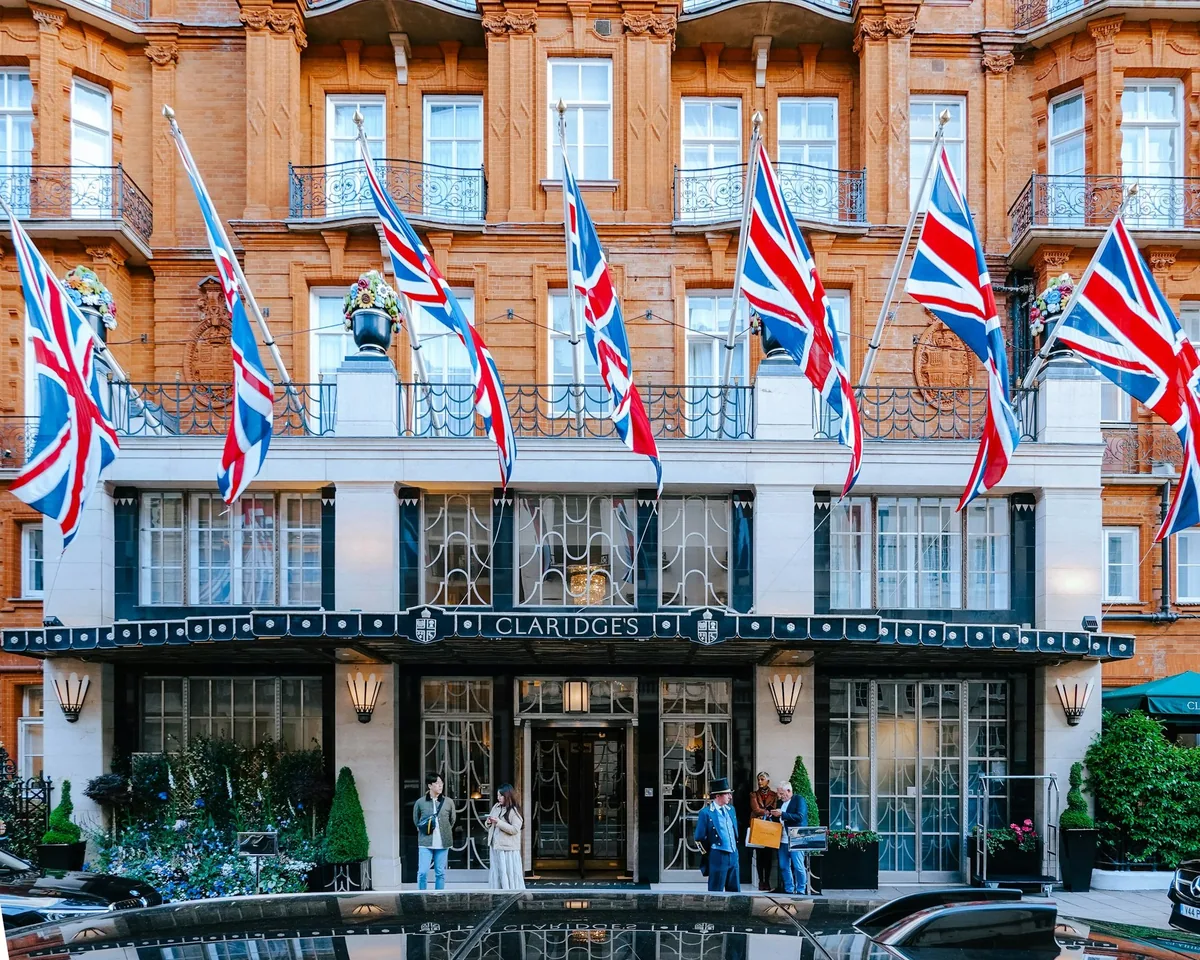 The red-brick facade of a grand Mayfair hotel hung with rows of Union flags above the entrance
