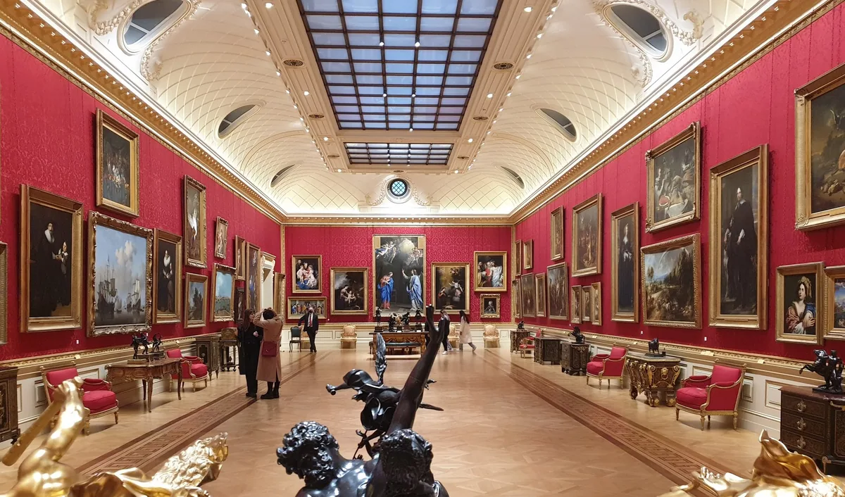 The nearly empty red-walled Great Gallery of the Wallace Collection hung with old master paintings