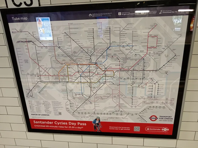 A framed Tube map mounted on the tiled wall of a London Underground station