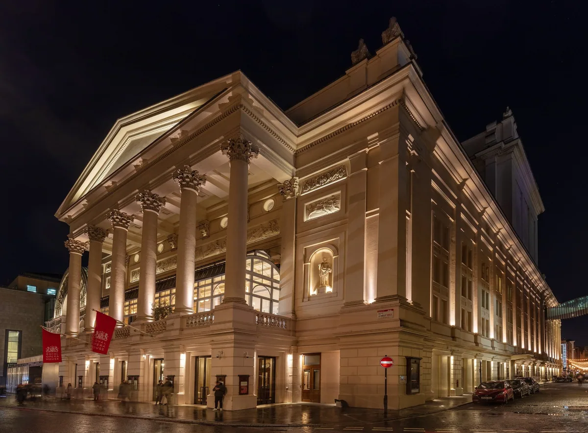 The floodlit colonnaded front of the Royal Opera House in Covent Garden at night