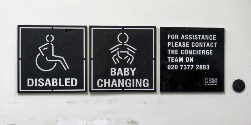 Disabled and baby changing toilet signs on a door at Spitalfields Market