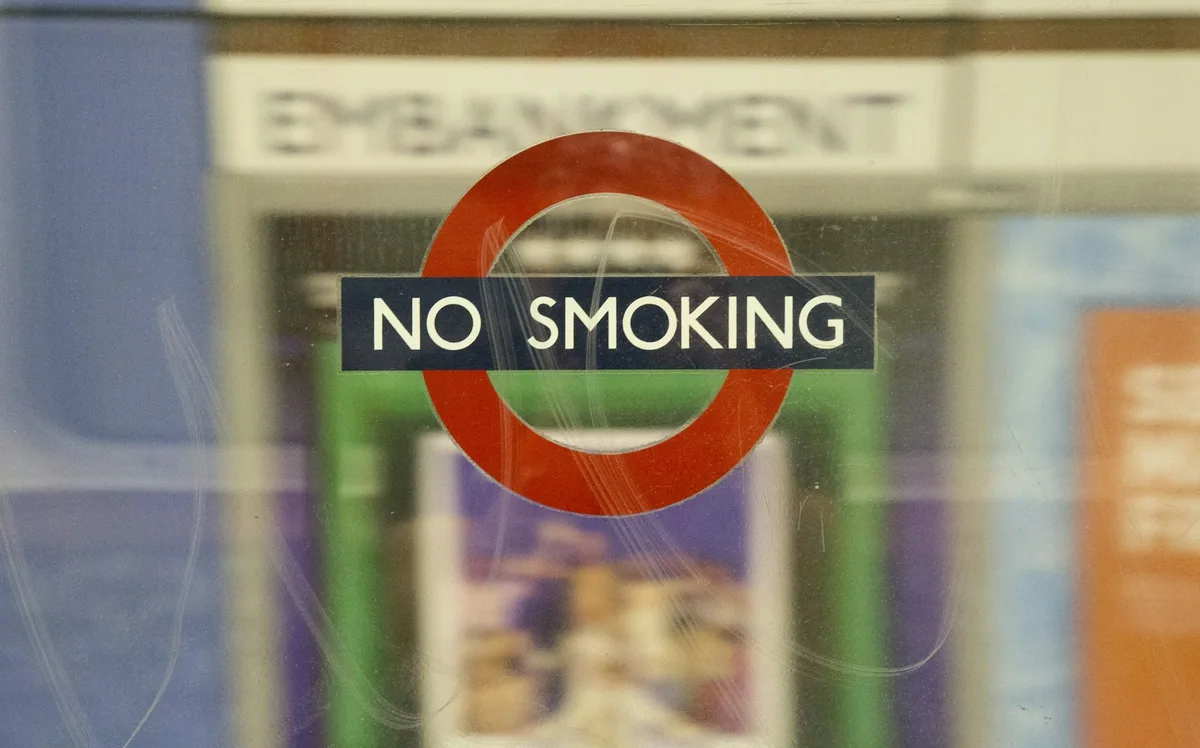 A No Smoking roundel sign on the wall at Embankment Underground station