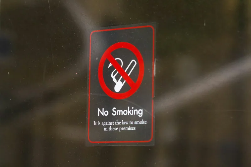 A No Smoking notice on a glass door stating that it is against the law to smoke in these premises