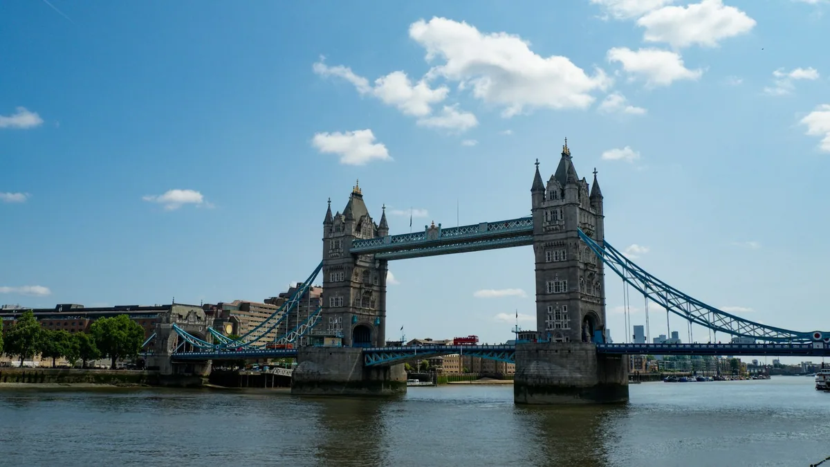 Tower Bridge spanning the Thames on a sunny day with white clouds overhead