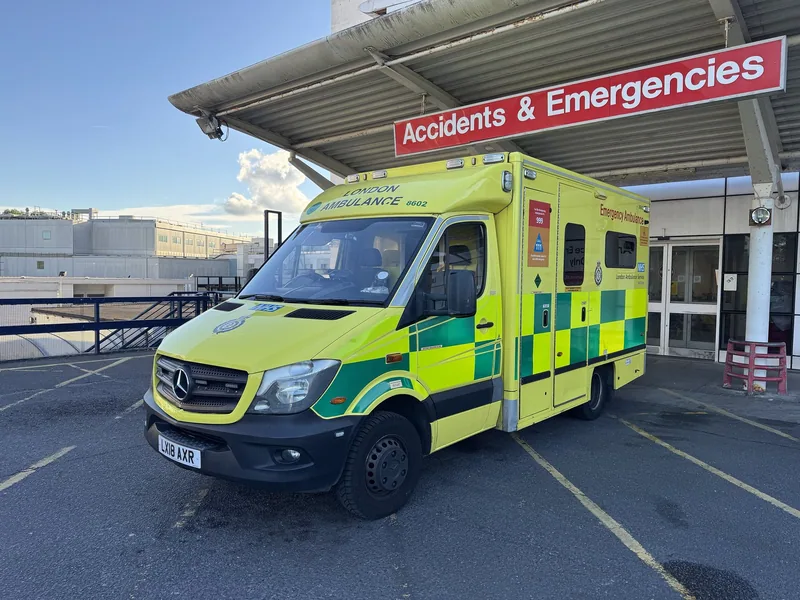 An ambulance parked under an Accidents and Emergencies sign at a hospital entrance