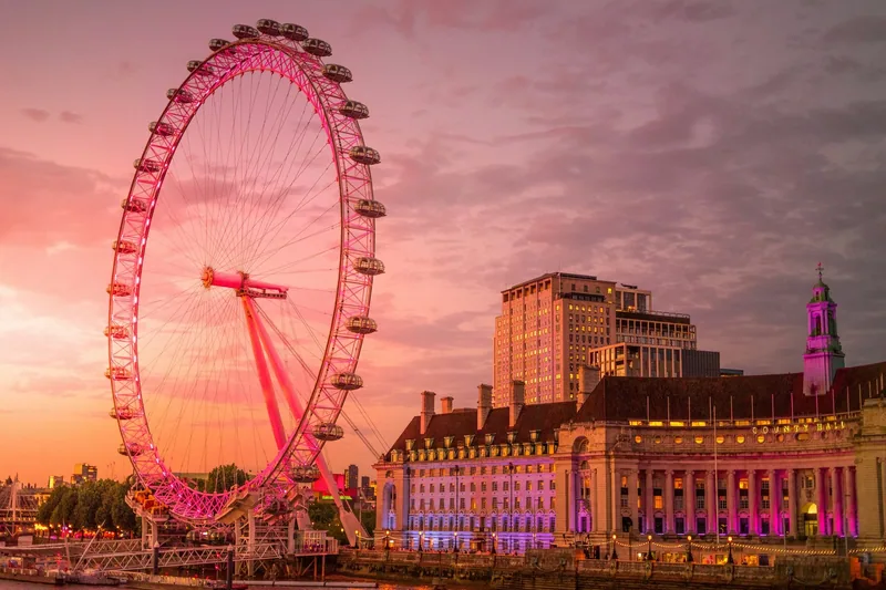 London Eye and County Hall on the South Bank under a pink sunset sky
