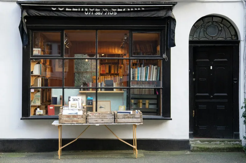 A second-hand bookshop window with a folding table of books set out on the pavement