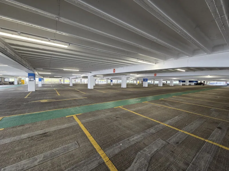 An almost empty deck of the multi-storey car park at Brent Cross, its bays marked out in yellow with a green walking lane across them