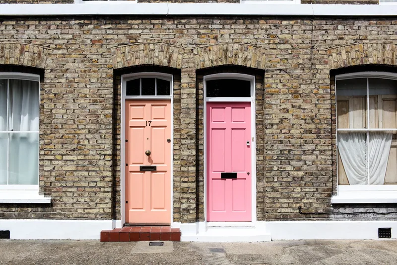 Peach and pink front doors in a yellow-brick terrace on Columbia Road