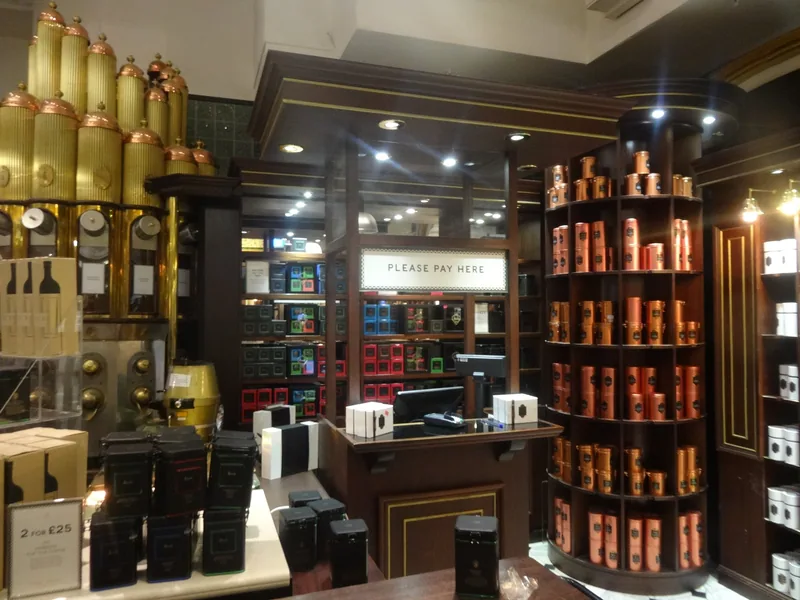 The tea and coffee counter inside Harrods, with copper caddies stacked on curved shelves