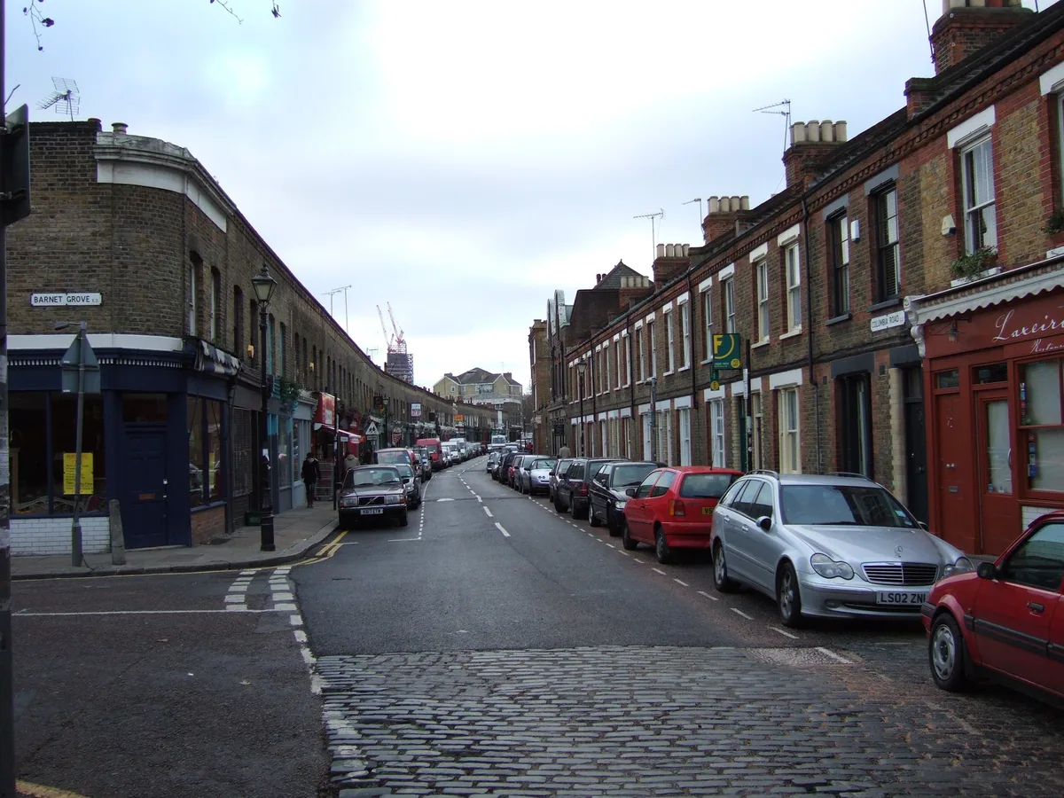 Columbia Road empty of stalls on a weekday morning, cars parked along the brick terraces