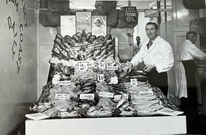 A fishmonger behind a display of kippers and smoked haddock at Tooting Market in the 1940s