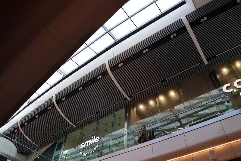 Two shopping levels inside Westfield Stratford City, with lit shopfronts and a curved balcony