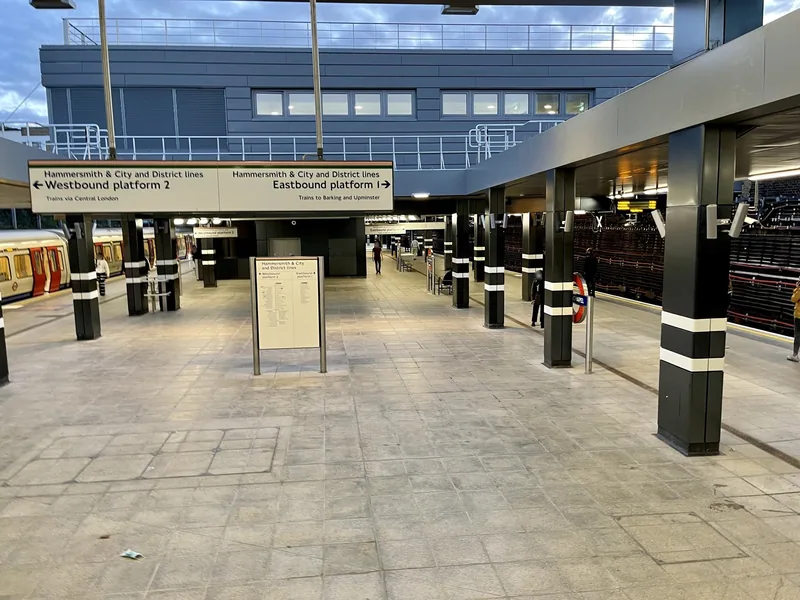 The empty Underground platforms at Whitechapel station under a daylit canopy