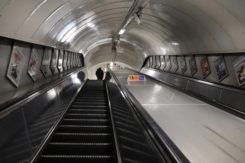 Escalators rising through the tiled tunnel at Oxford Circus Underground station