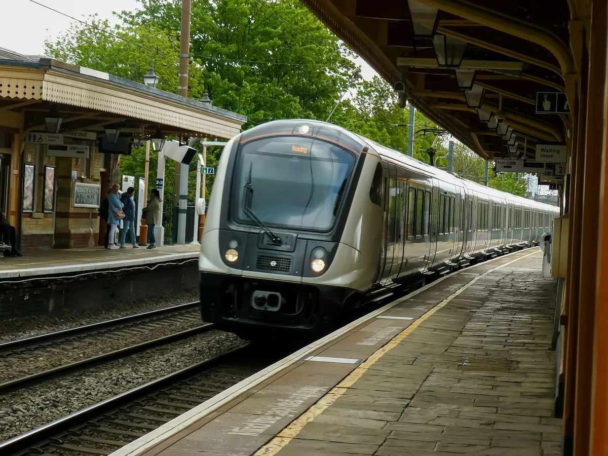 Purple and white Elizabeth line train pulling into the platform at Hanwell station