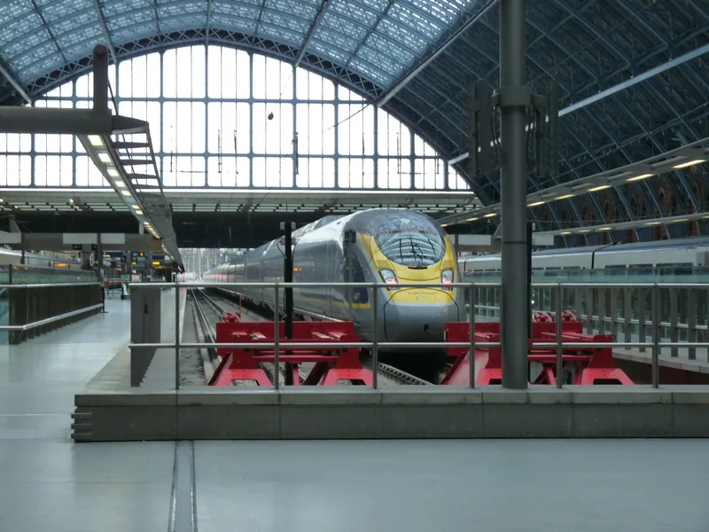 Eurostar e320 train waiting at a platform beneath the glass train shed of St Pancras station
