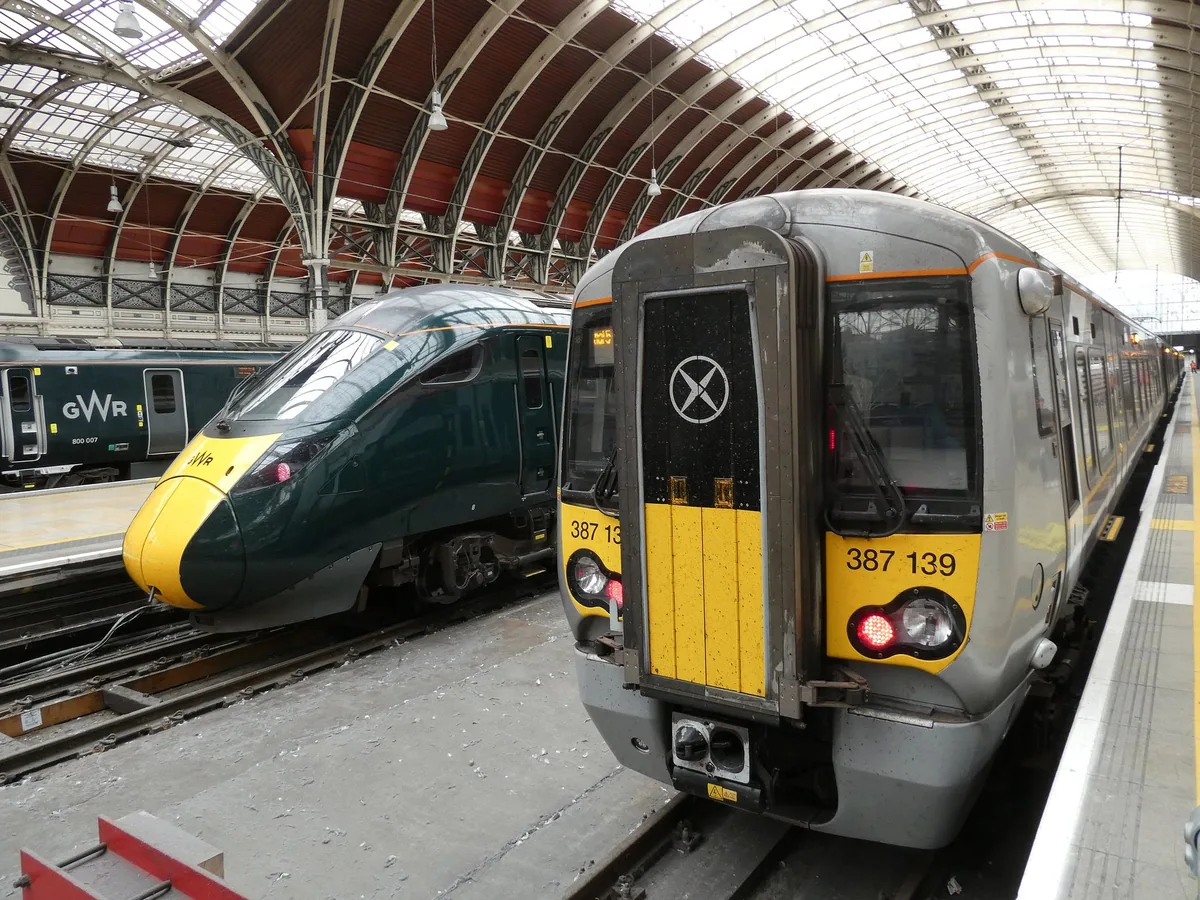 A Heathrow Express train waiting beside a Great Western service under the arched roof of Paddington station