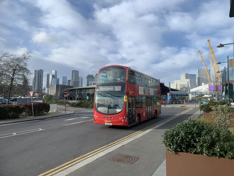 A red double-decker on route SL11 to Abbey Wood pulling away from North Greenwich bus station