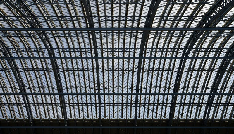 The iron and glass Barlow trainshed roof of St Pancras station seen from below