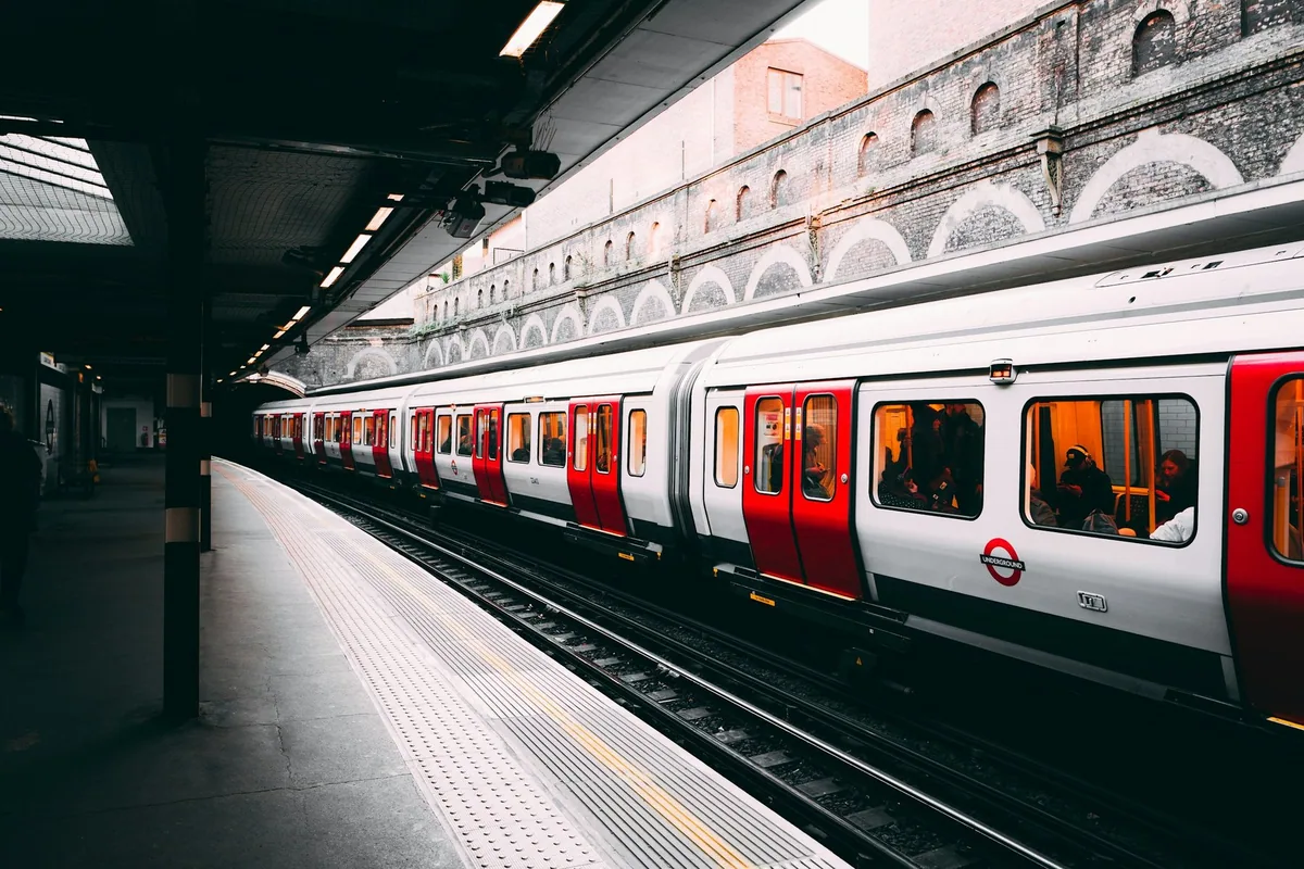 Red, white and blue London Underground train waiting at the platform of Sloane Square station