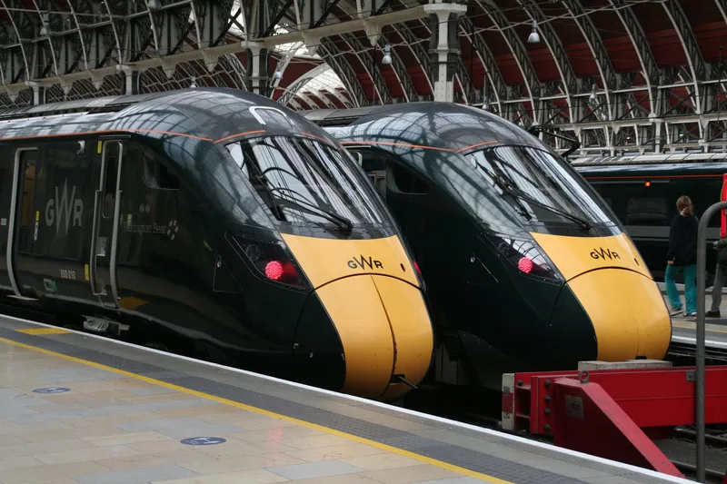 Two green and yellow GWR express trains standing nose to nose at the Paddington buffer stops