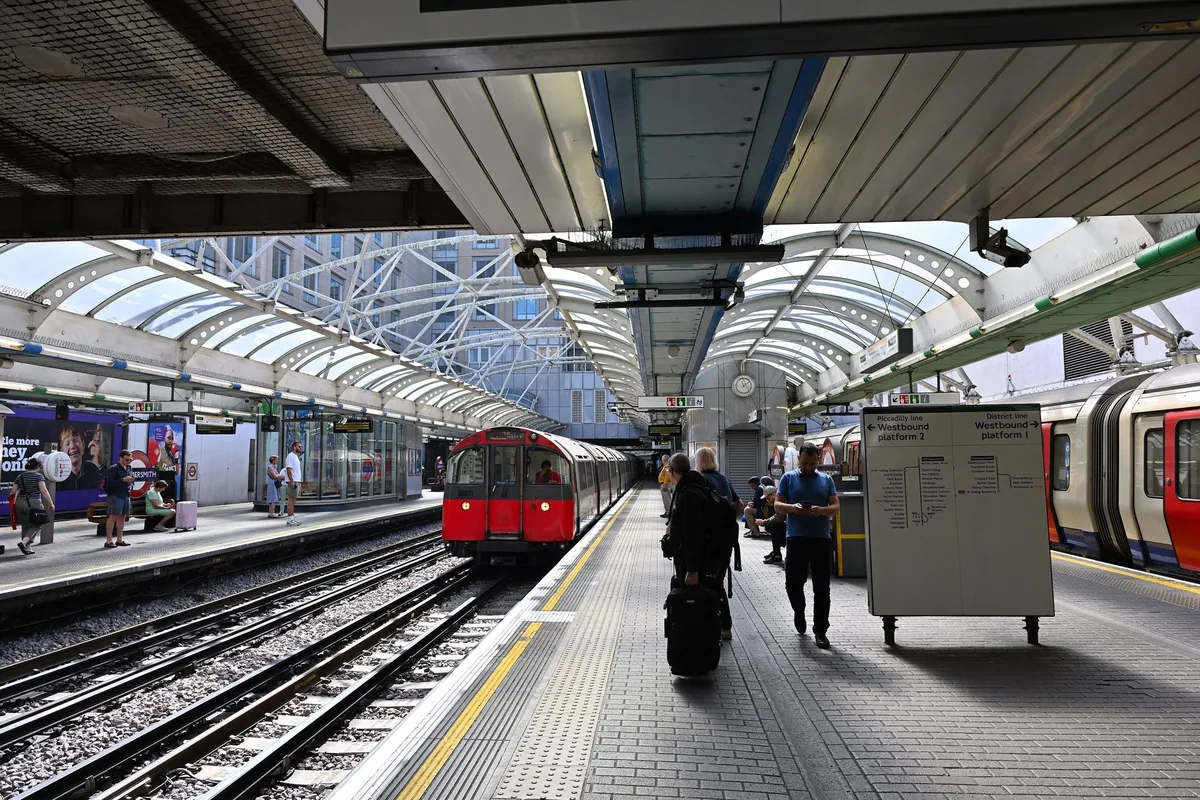 A Piccadilly line tube train running into the arched platform at Hammersmith station