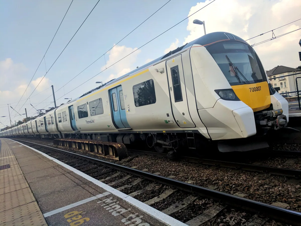 A white and yellow Thameslink Class 700 train standing at a platform at Cricklewood