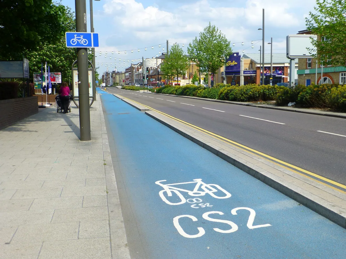 A blue segregated cycle lane marked CS2 running alongside a main road in Stratford, east London