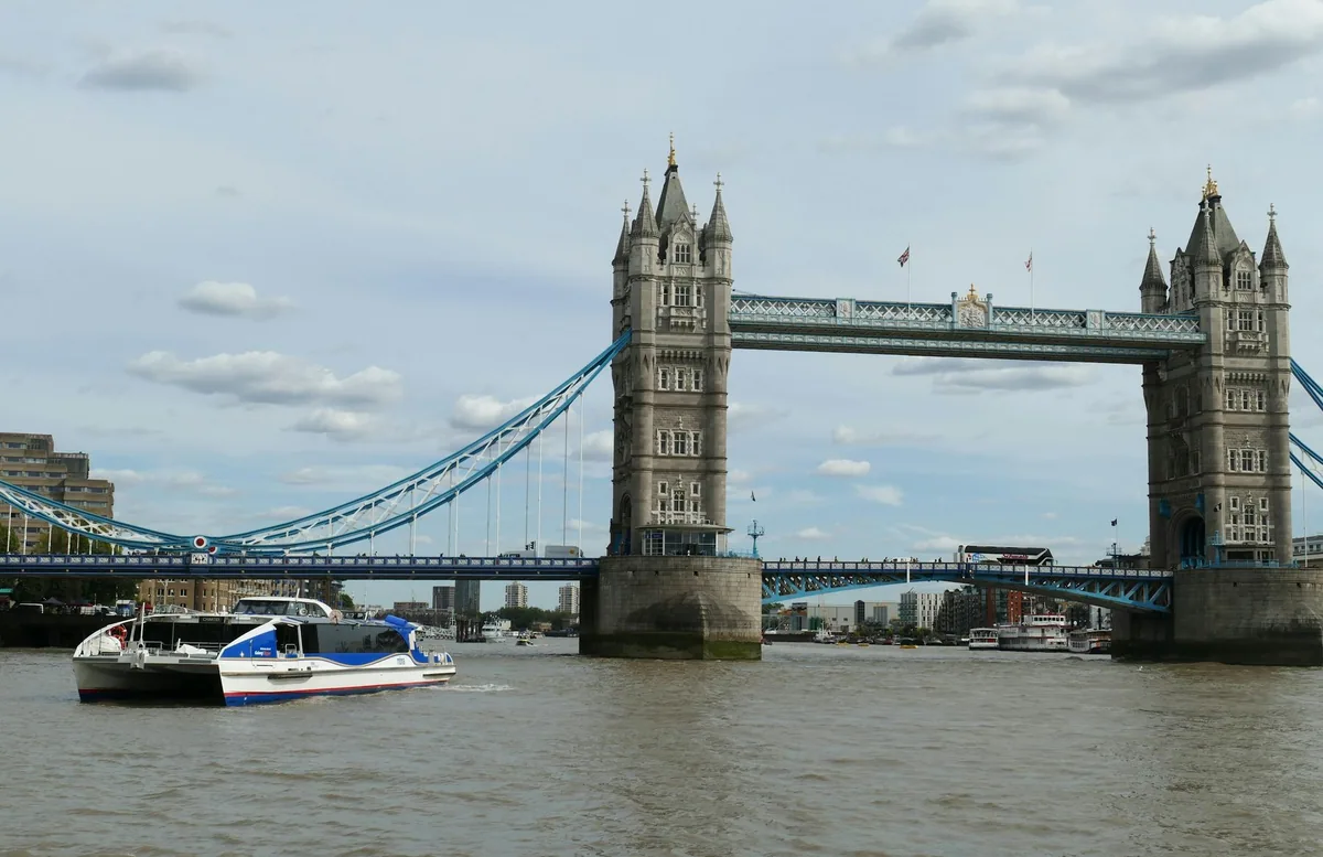 Thames Clipper catamaran on the River Thames passing in front of Tower Bridge