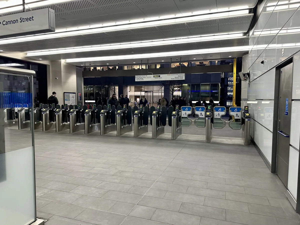 A long row of ticket gates at the Cannon Street entrance to Bank Underground station, seen from inside the gateline