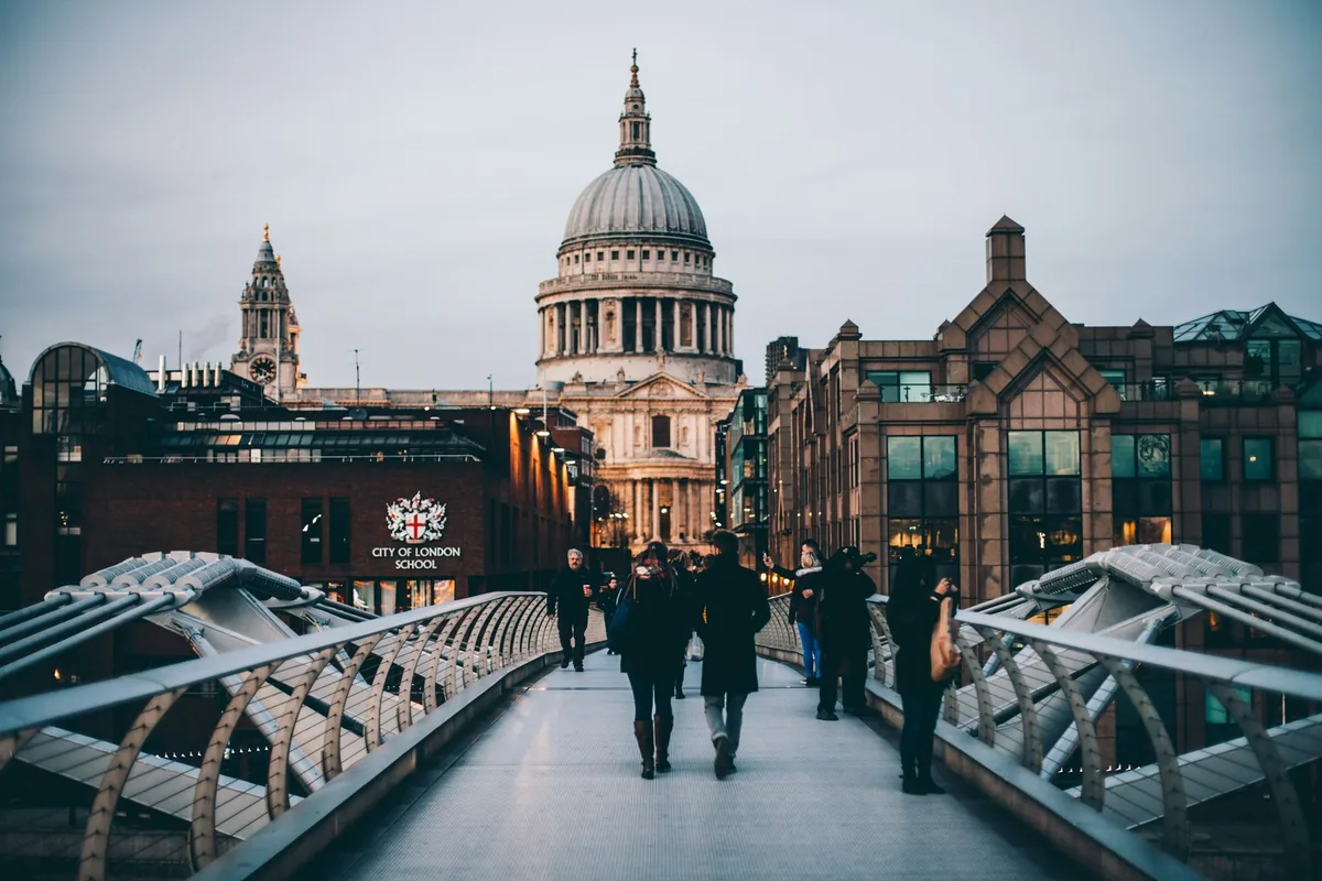 Pedestrians crossing the Millennium Bridge towards the dome of St Paul's Cathedral