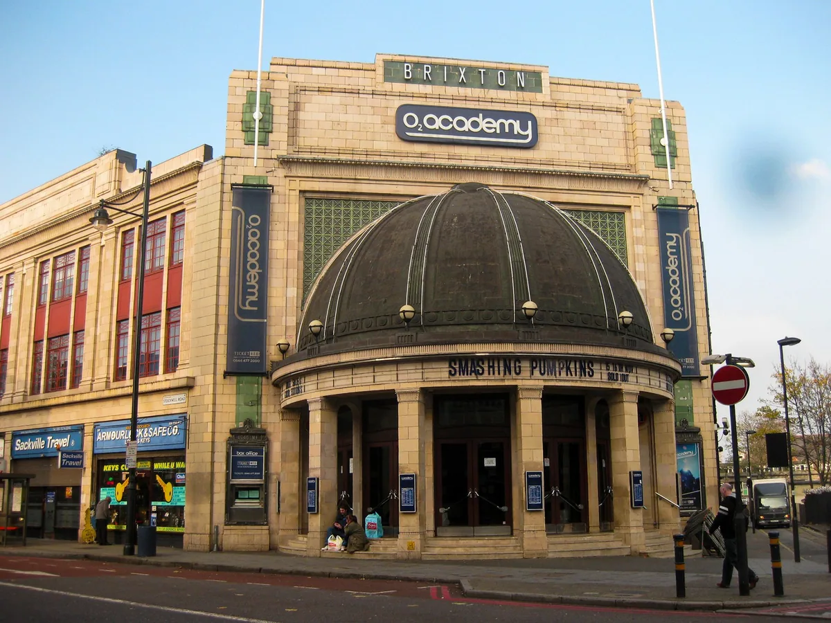 The art deco frontage and copper dome of Brixton Academy on a clear day