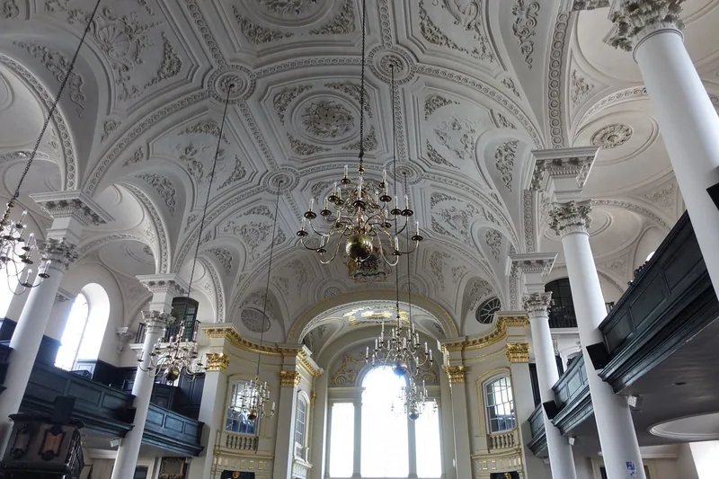 The barrel-vaulted plaster ceiling and galleries of St Martin-in-the-Fields, chandeliers hanging over the empty nave