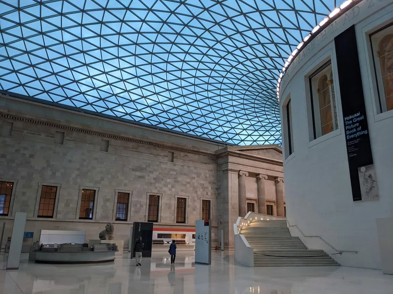 The Great Court of the British Museum almost empty under its glass and steel roof, with only a few visitors left