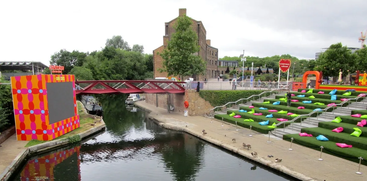 Open-air cinema screen beside Regent's Canal at King's Cross, with beanbags on the canalside steps
