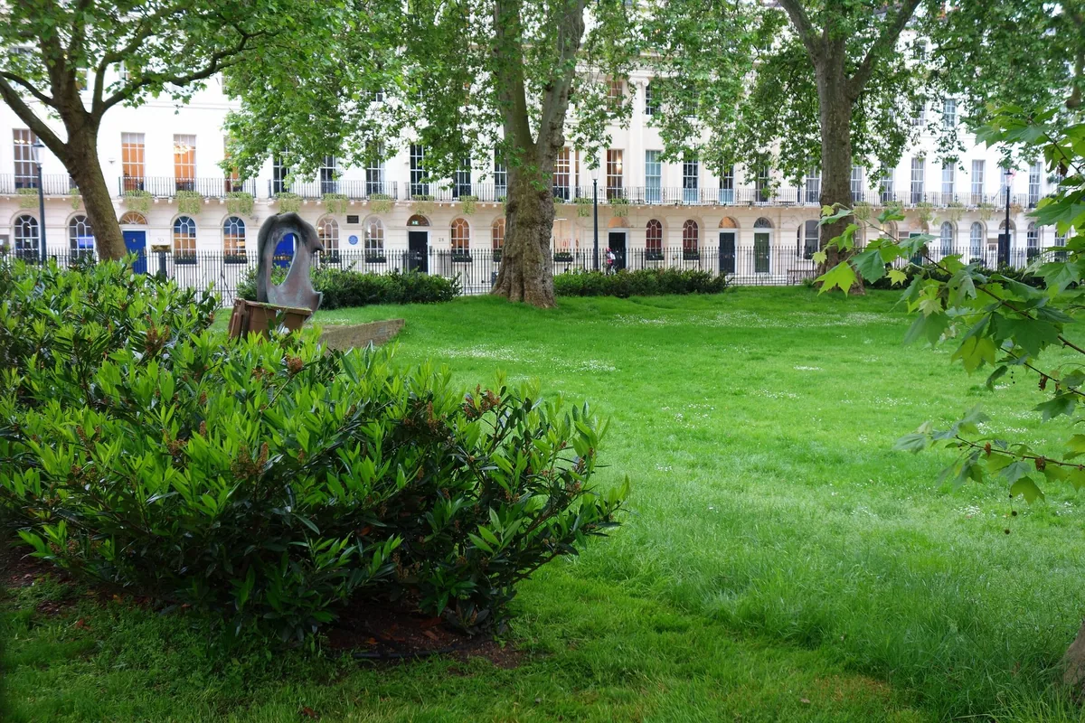 The railed lawn of Fitzroy Square Garden with the square's Georgian terrace behind the plane trees